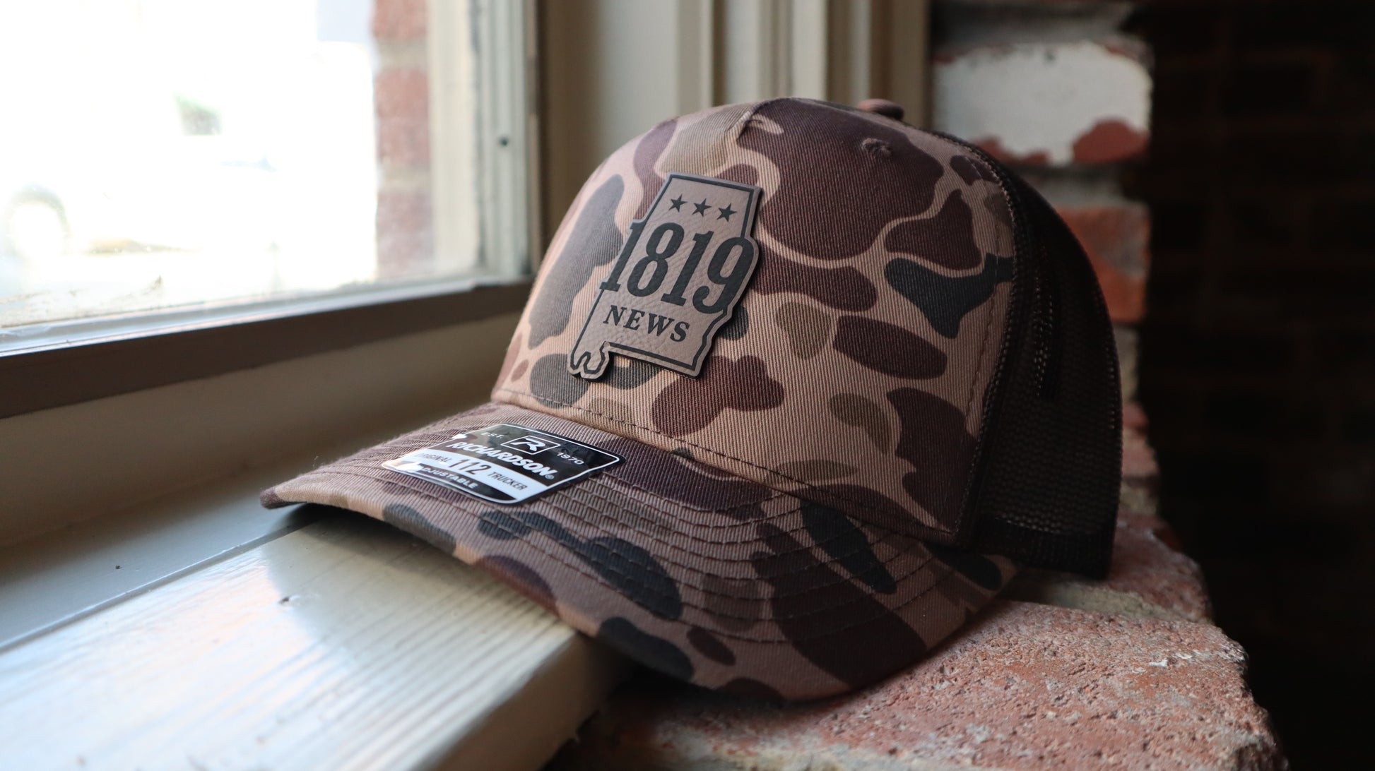 Camouflage baseball cap with 1819 News branding 